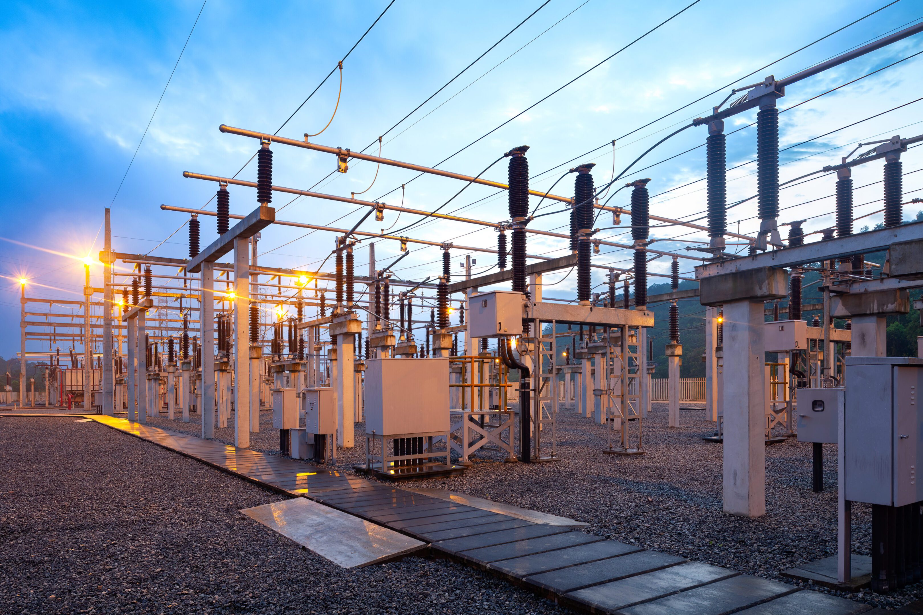 Electrical substation at sunrise with equipment.