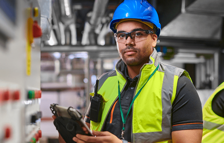 Worker with tablet in industrial setting.